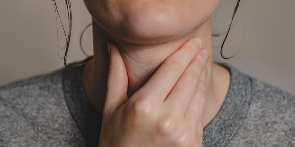 woman holding her throat